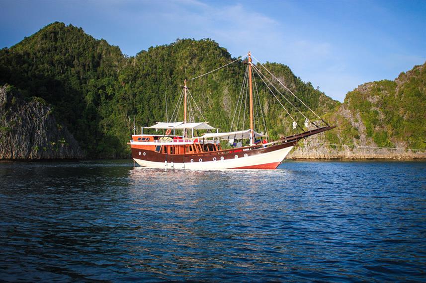 Akomo boat next to lush green islands.