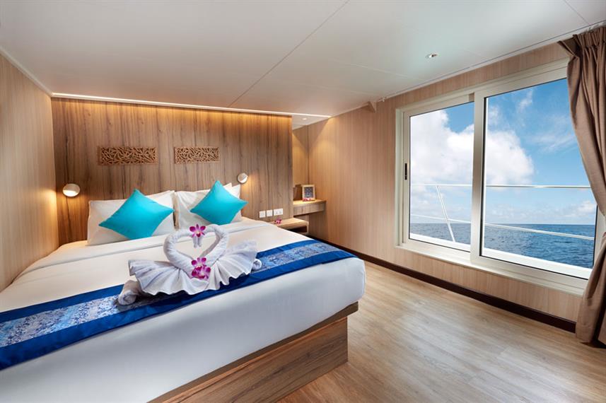 Upper deck cabin of gaia love with window and double bed.