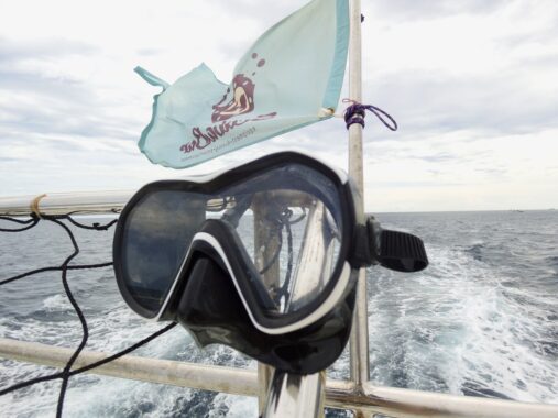 Aqualung Reveal X1 on boat rigging with flag and ocean behind it.