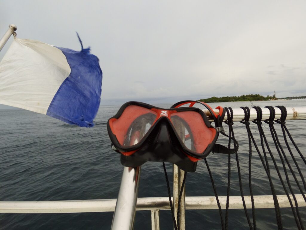 Mares X Vision Ultra on boat rigging with flag and island in background.