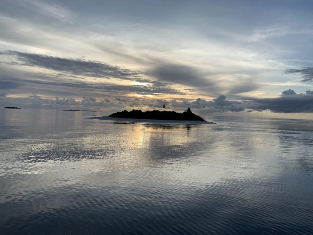 Maldivian island at sunset during liveaboard trip.