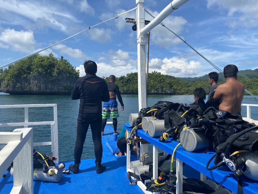 Group of Filipino Dive Instructors approaching Philippines dive site aboard dive boat.