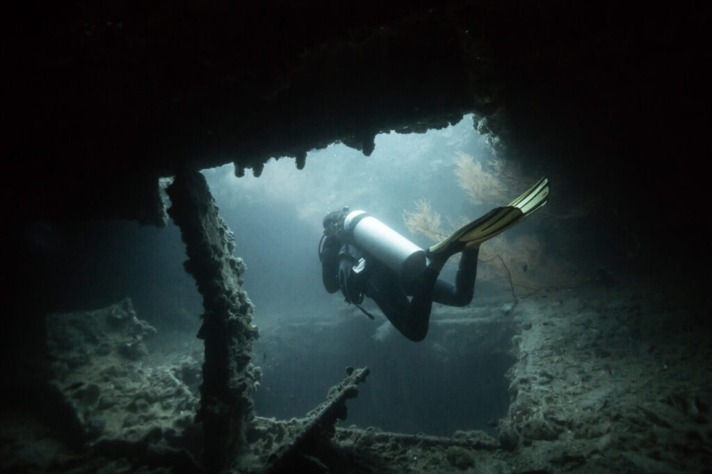 Scuba diver exploring shipwreck in Coron Bay.