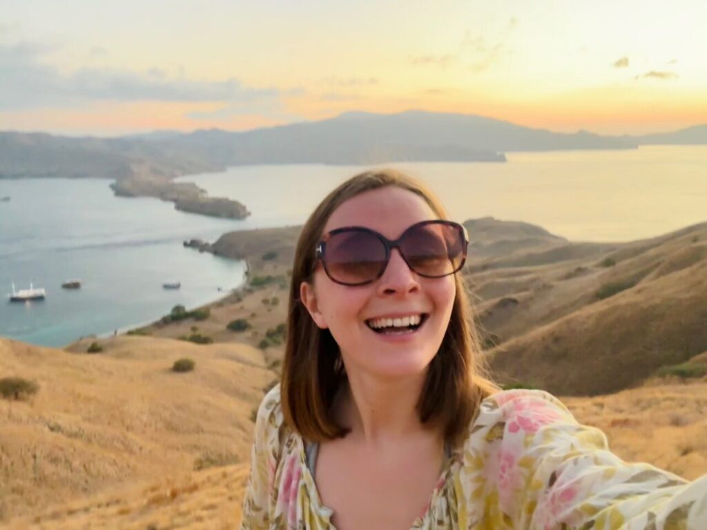 Selfie of Jasmin on Gili Lawa with the beautiful view of the bay and a sunset
