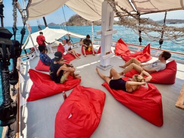 The shaded sun deck of the akomo isseki liveaboard with its characteristic red bean bags