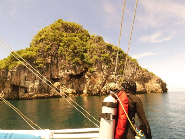Scuba diver on boat looking at Gato Island
