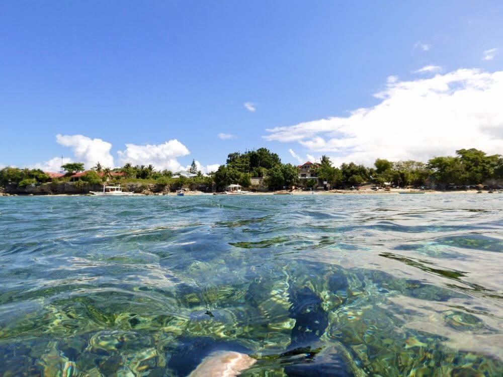 View of white sand beach of Moalboal from dive boat.