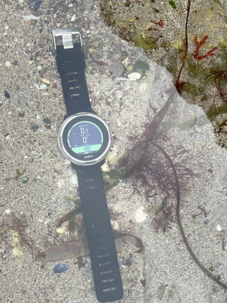 Suunto D5 dive computer on sand bed in rockpool. Original photo.