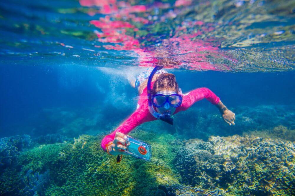 woman snorkeling with camera shutterstock underwater photography whilst snorkeling.